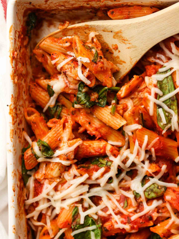 no boil pasta bake with spinach and daiya cheese on top wooden spoon