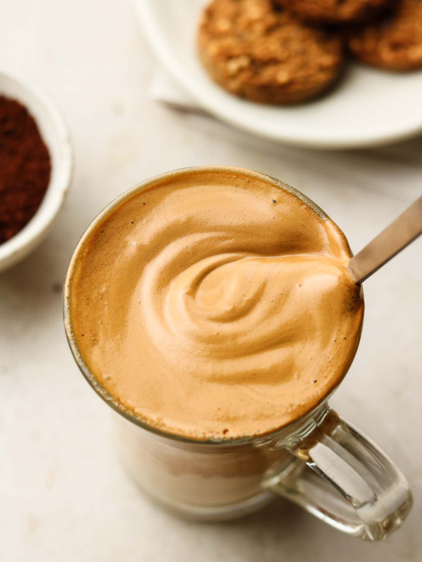 non dairy cappuccino in a glass cup with frothy coffee on top