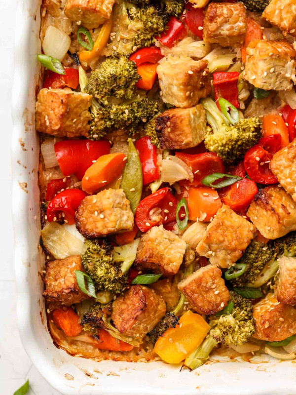 rice, tempeh and vegetables covered in sesame ginger sauce in casserole dish