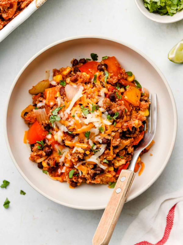 quinoa mexican taco casserole in a white bowl with dairy free cheese on top