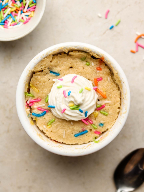 vanilla cake with sprinkles in a bowl with cream on top
