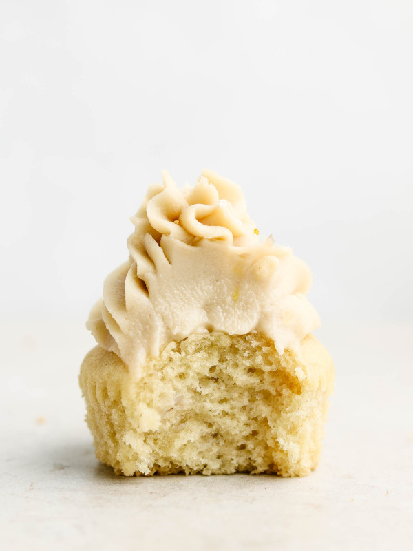 single fluffy vanilla cupcake with a bite taken out of it