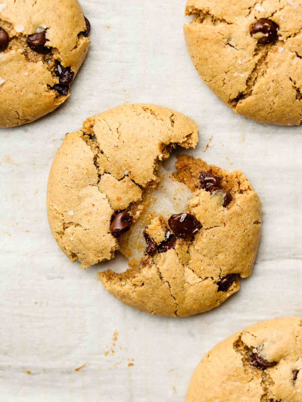 mochi stuffed chocolate chip cookies broken in half on parchment paper