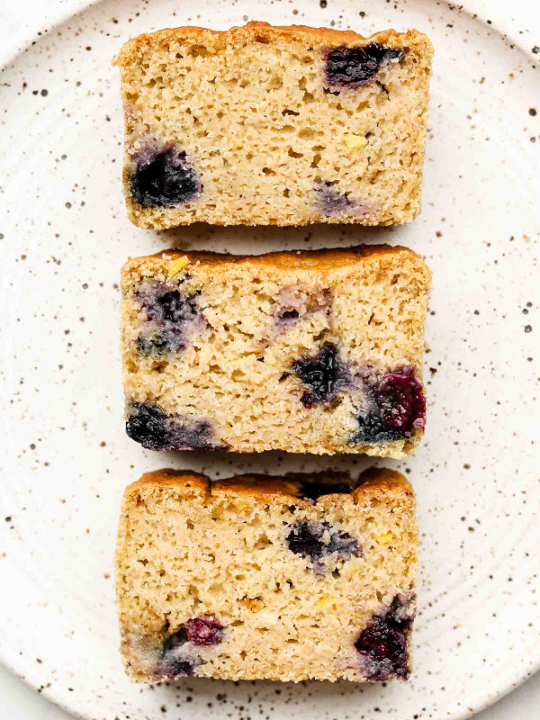 lemon blueberry loaf cake on a speckled white plate