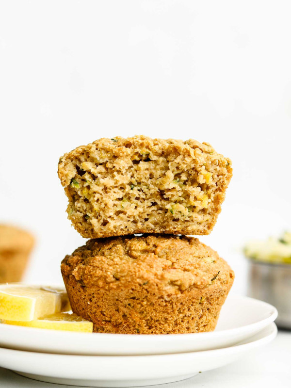 two lemon muffins stacked on each other with top muffin cut in half