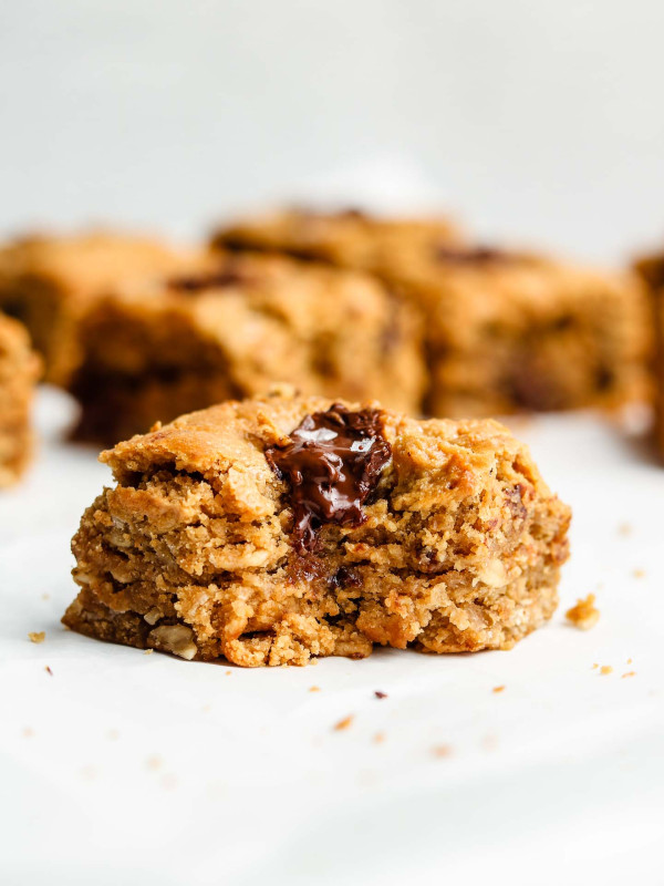 close up shot of vegan chocolate chip oatmeal cookie bar with a bite taken out of it