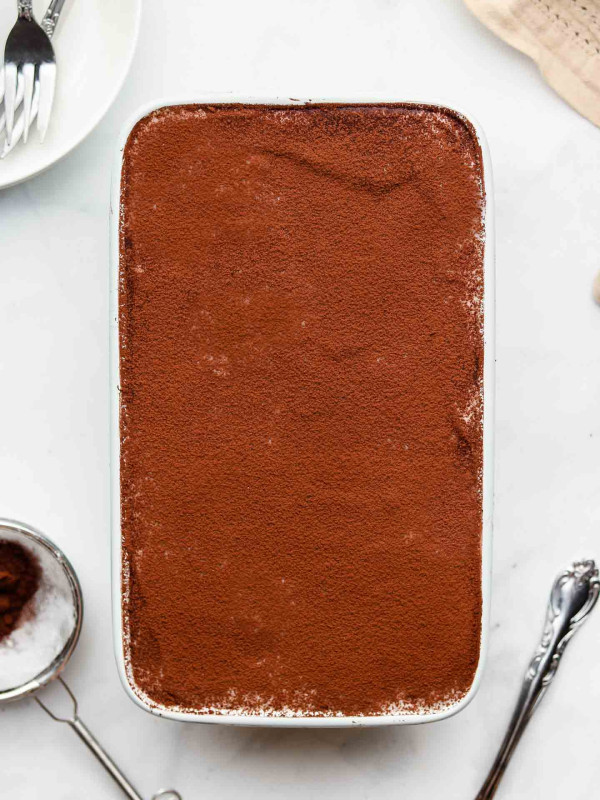 vegan dairy free tiramisu in a loaf pan with cocoa powder on top