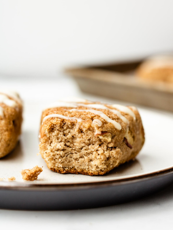 apple cinnamon sugar scones with a bite taken out of it on a white and blue ceramic plate
