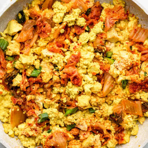 scrambled tofu with kimchi in a white speckled pink pan