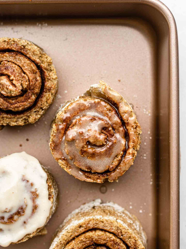 mini cinnamon rolls with glaze in a small rose gold pan