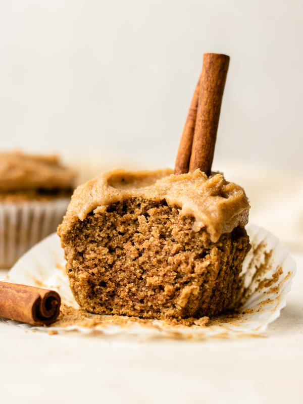 brown chai cupcake with chai frosting and a cinnamon stick on top, with a bite shot