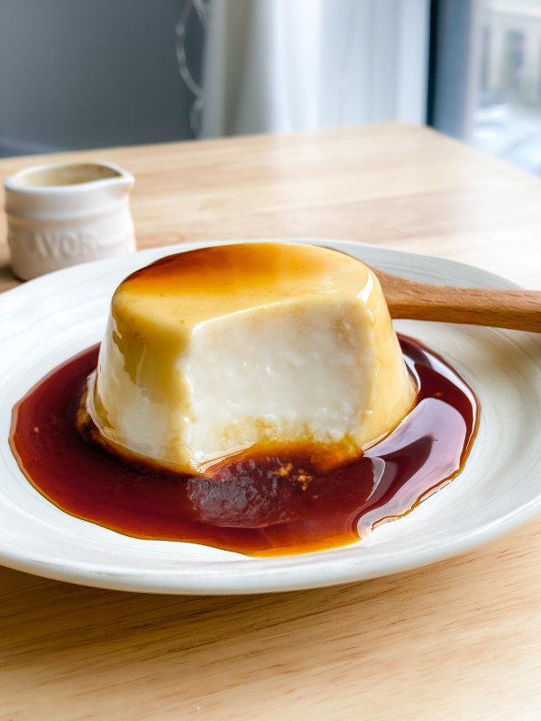vegan purin on a white plate with caramel sauce
