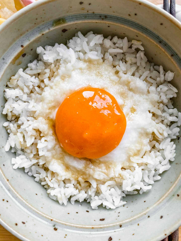 vegan egg yolk over rice in a ceramic green bowl