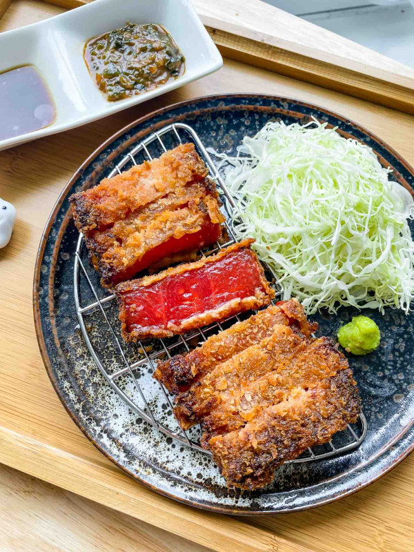 vegan watermelon katsu on a wire rack with cabbage and wasabi beside it