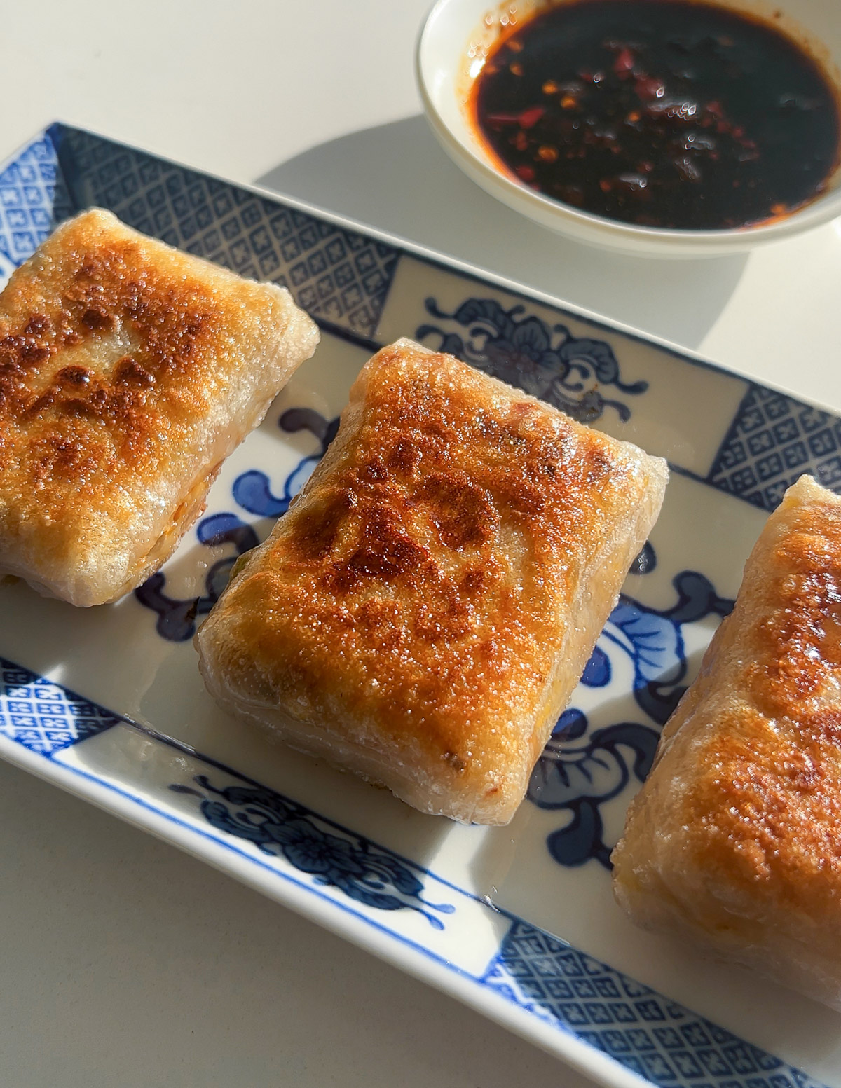 golden crispy rice paper dumplings on a blue plate
