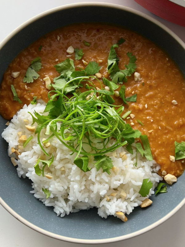gochujang lentils and rice with scallions and cilantro in a blue bowl
