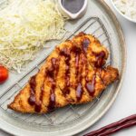 crispy air fried chicken katsu on a wire rack plate with tonkatsu sauce