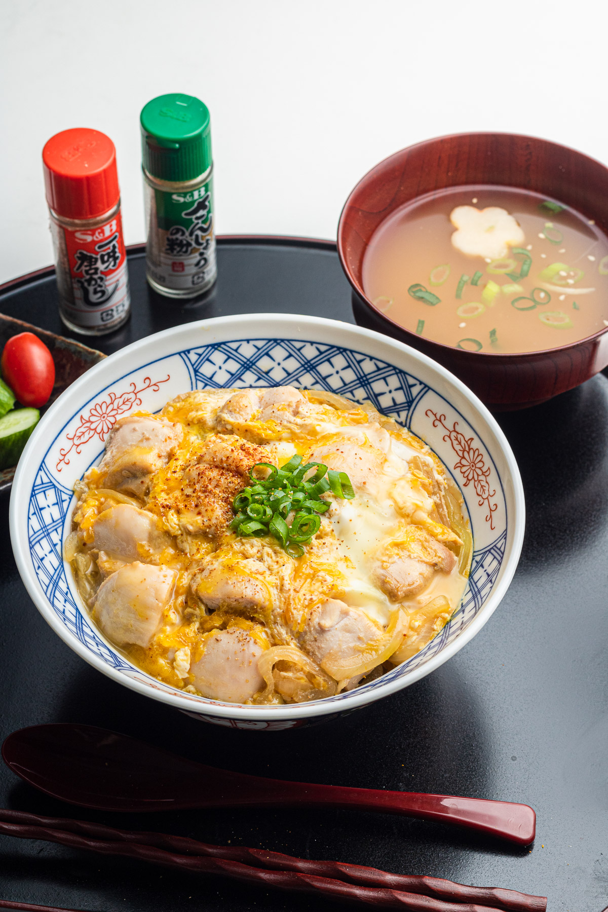 authentic oyakodon in a bowl on a black tray with miso soup