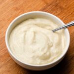 vanilla bean custard cream in a white bowl with a spoon
