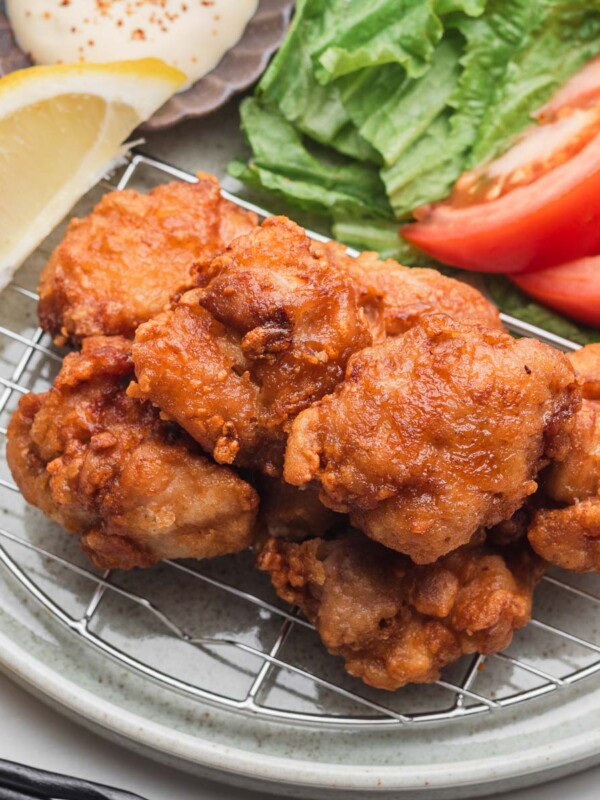 chicken karaage on a wire rack with lemon and side salad