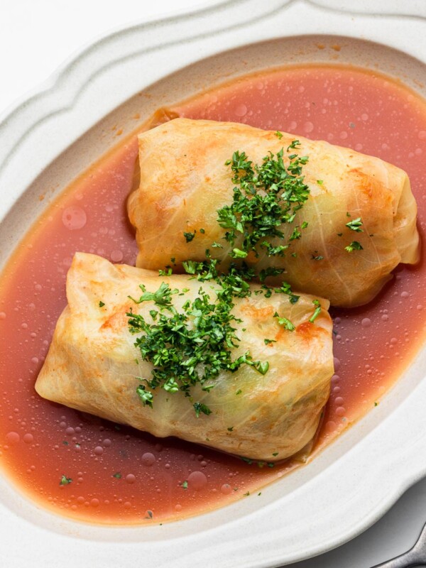 japanese cabbage rolls in tomato broth in a white oval bowl