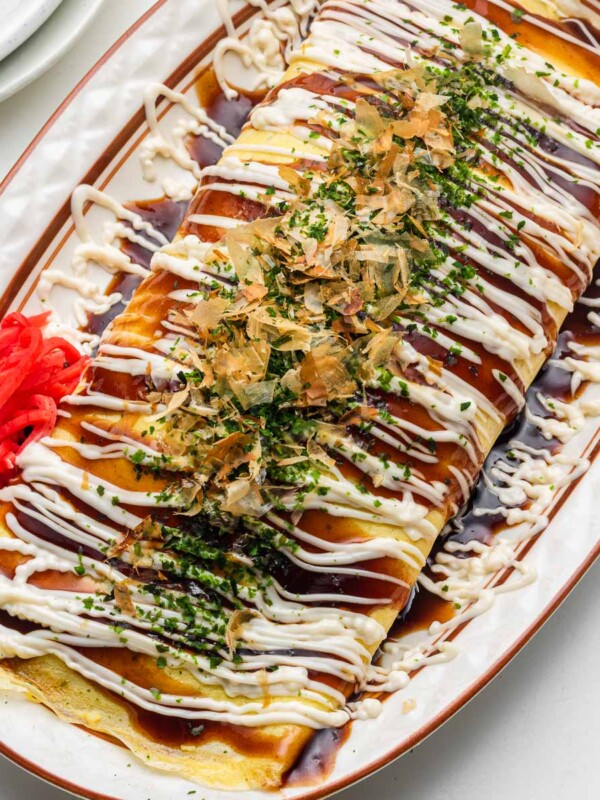 tonpeiyaki pork cabbage omelette on a oval plate with okonomiyaki sauce and kewpie mayo