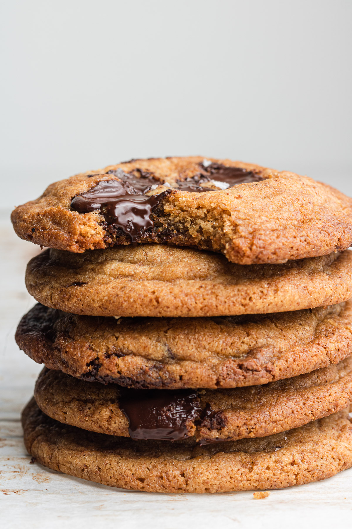 brown butter chocolate chip cookies stacked with a bite taken out of it