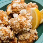 crispy chicken karaage on a teal plate with lemon