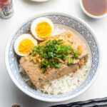 braised tofu over rice with soft boiled eggs, scallions and tempura scraps