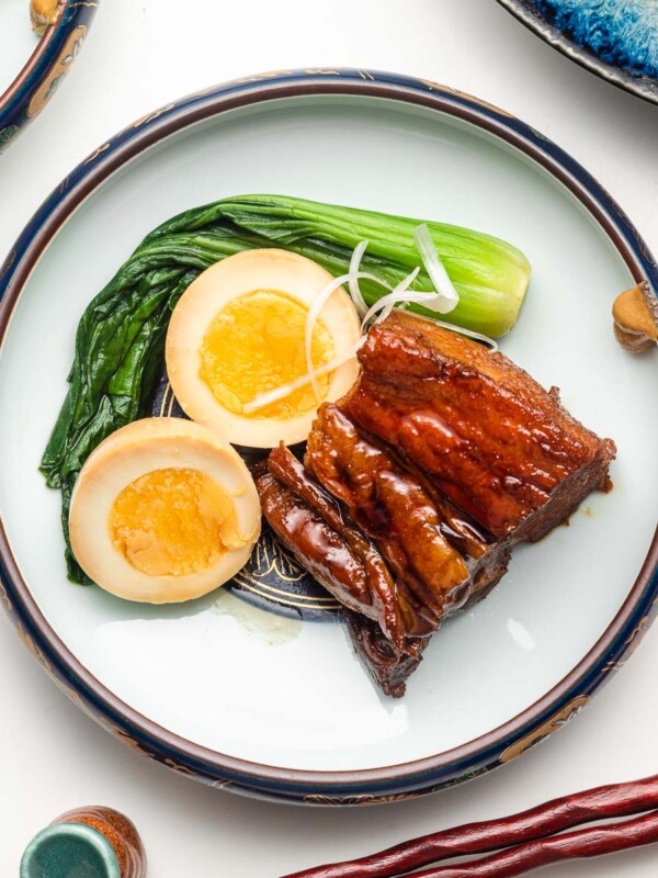 kakuni japanese braised pork belly on a serving plate with eggs and bok choy
