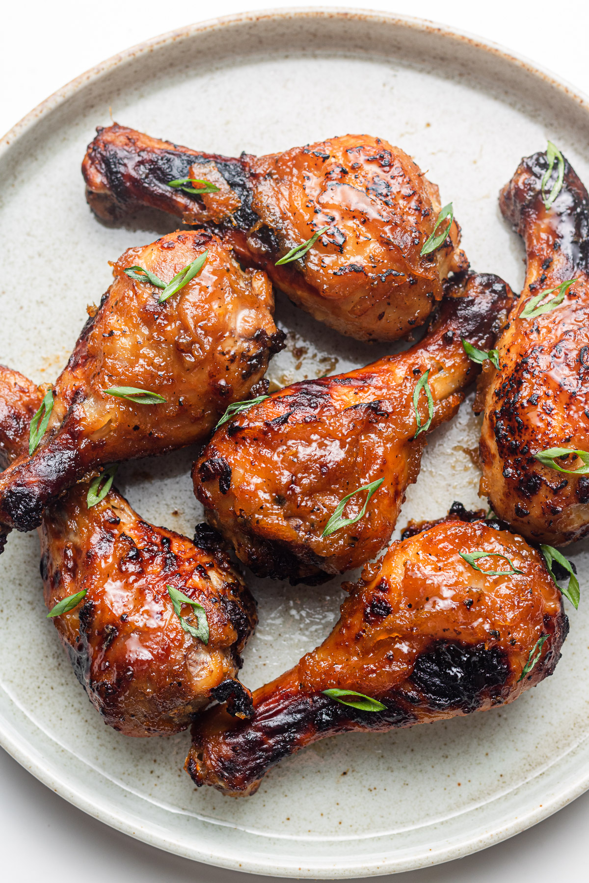 sticky asian chicken drumsticks on a ceramic plate