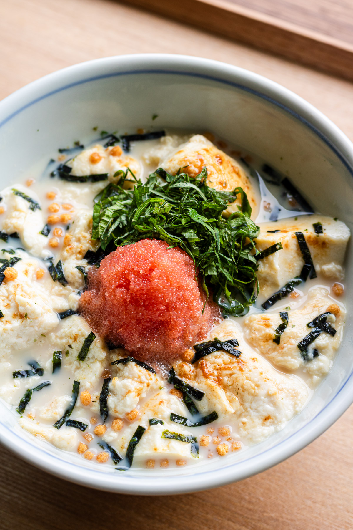 cold tofu with mentaiko, shiso and nori in a blue donburi bowl