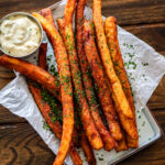 long fries on parchment paper with garlic mayo