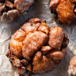 brown butter glazed apple fritter donut on parchment paper