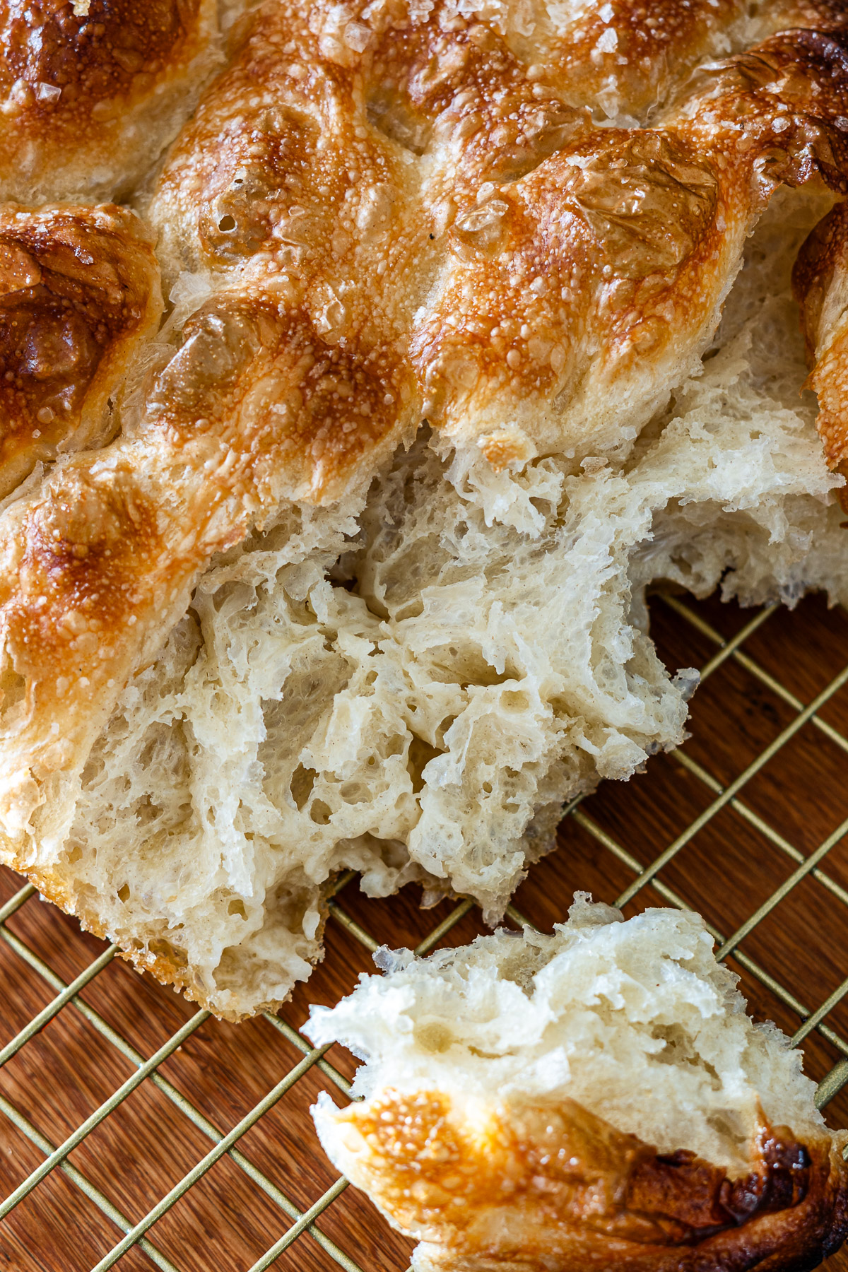 tearing croissant focaccia on a cooling rack