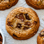 brown butter miso toffee cookies with dark chocolate on parchment paper