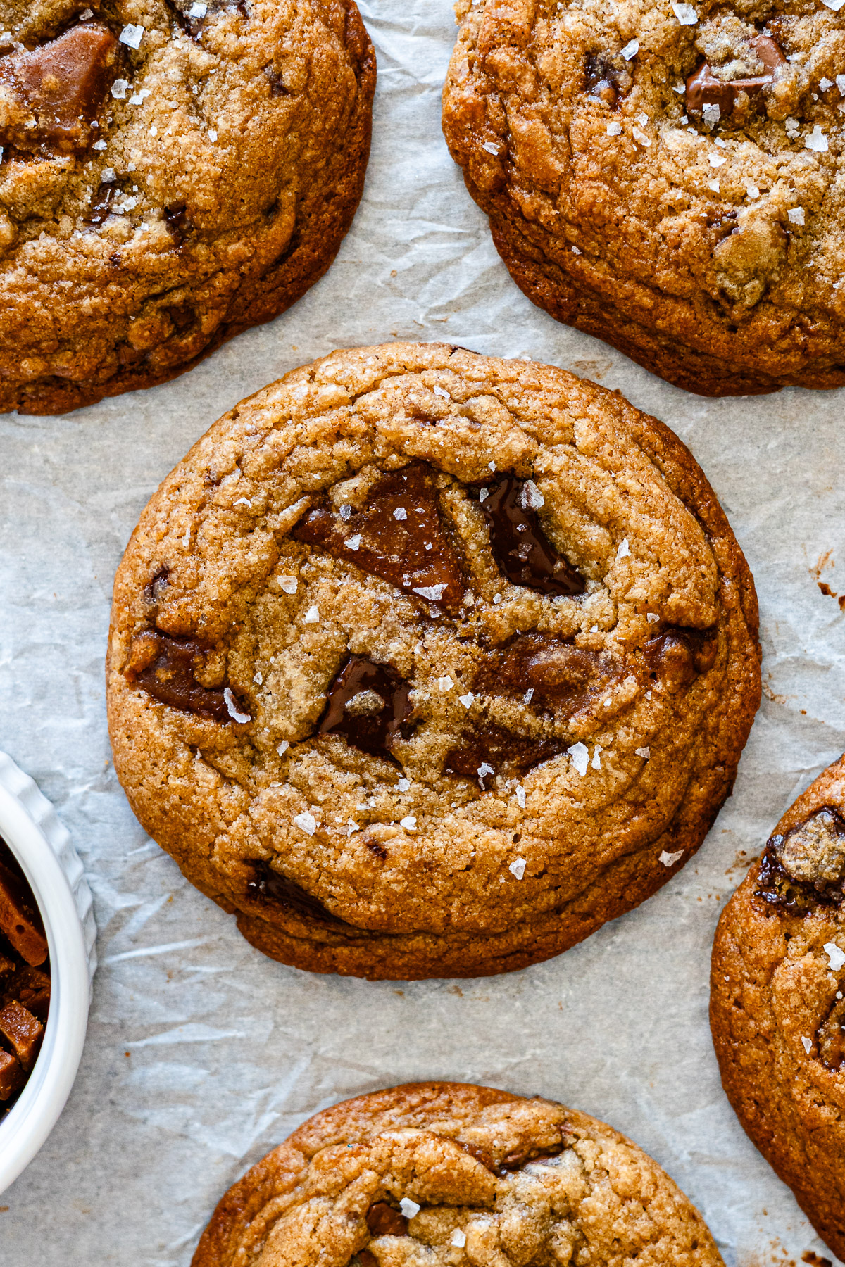 brown butter miso toffee cookies with dark chocolate on parchment paper