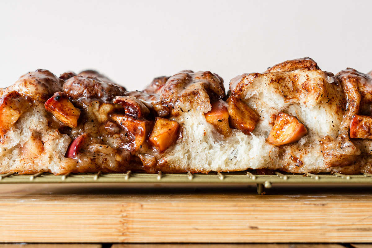 focaccia with cinnamon sugar apples and a brown butter maple glaze on a wire rack
