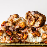 apple fritter focaccia pieces stacked with brown butter maple glaze