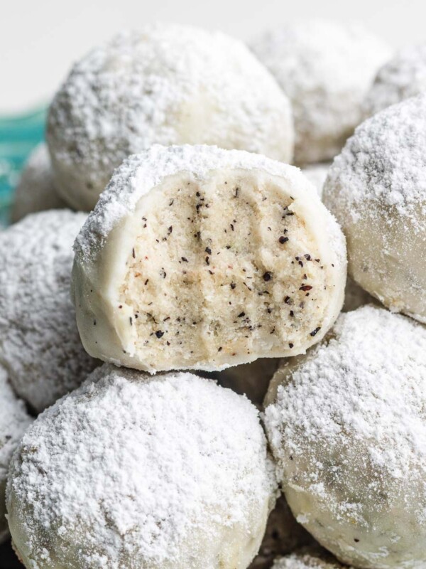 earl grey snowball cookies with cross section and stacked on other snowball cookies on a blue plate