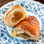 honey butter salt bread split in half on a blue plate with honey butter dripping out