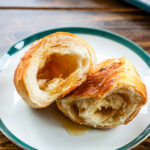 butter rolls with maple butter on a green rim plate