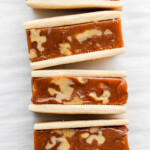 caramel walnut sandwich cookies lined up on parchment paper