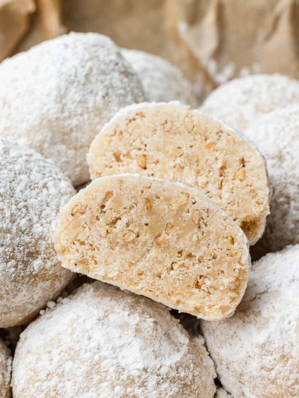 sesame snowball cookies cut into half stacked on other snowball cookies