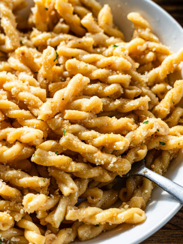 miso butter pasta in a white shallow bowl plate topped with crispy fried garlic panko