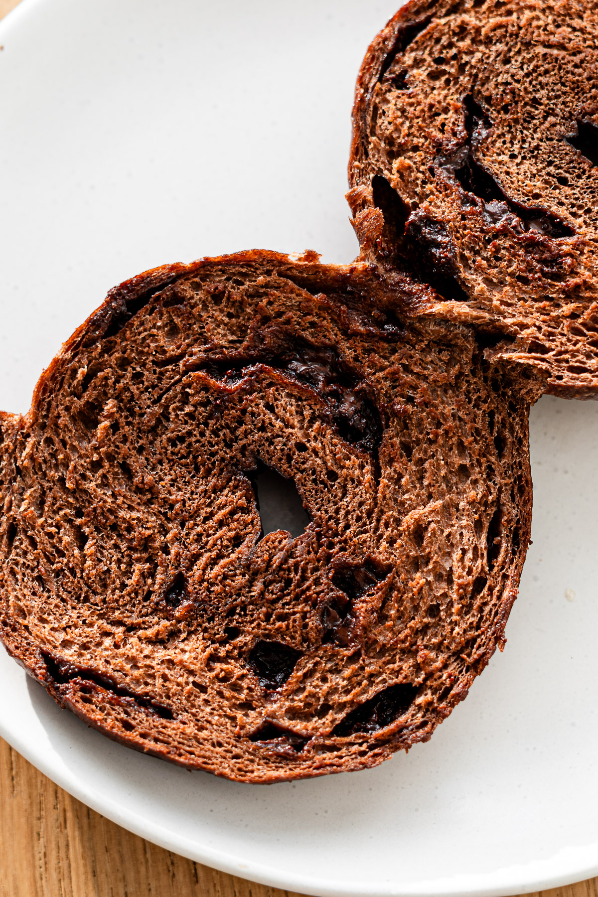 cross section of chocolate chip chocolate bagel on a white plate