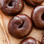 chocolate bagels on parchment paper on a pink tray