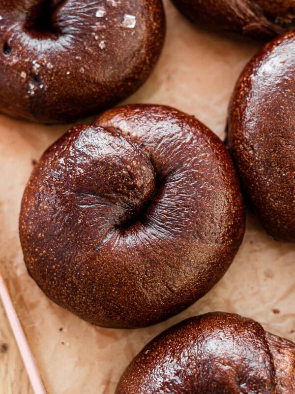 chocolate bagels on parchment paper on a pink tray