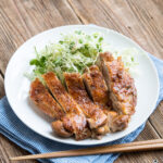 teriyaki chicken on a white plate with cabbage slaw