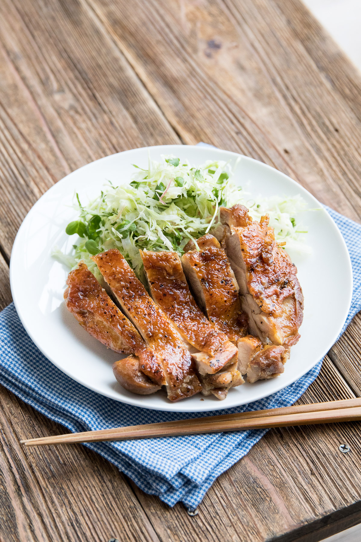 teriyaki chicken on a white plate with cabbage slaw